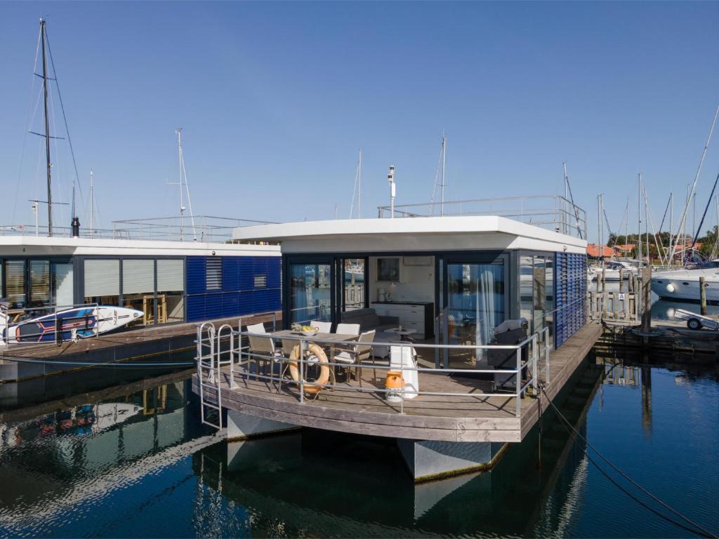 ein Boot liegt an einem Dock im Wasser in der Unterkunft Hausboot "Fjordblik" in Barth in Barth