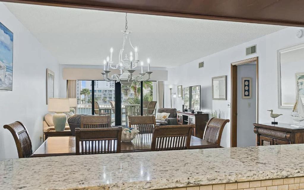 une cuisine et un salon avec une table et des chaises dans l'établissement Oceanfront Two Bedroom Condo with Balcony and Heated Pool, à Cocoa Beach
