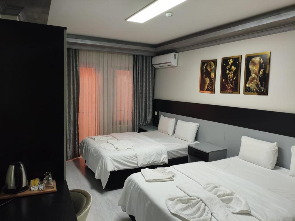 une chambre d'hôtel avec deux lits et une fenêtre dans l'établissement Retrol Butik Hotel, à Istanbul