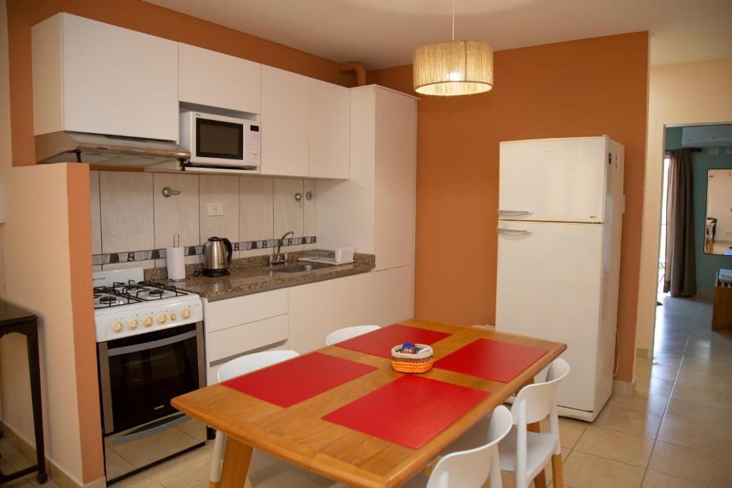 a kitchen with a wooden table and a white refrigerator at Centro Perú 2 in Paraná