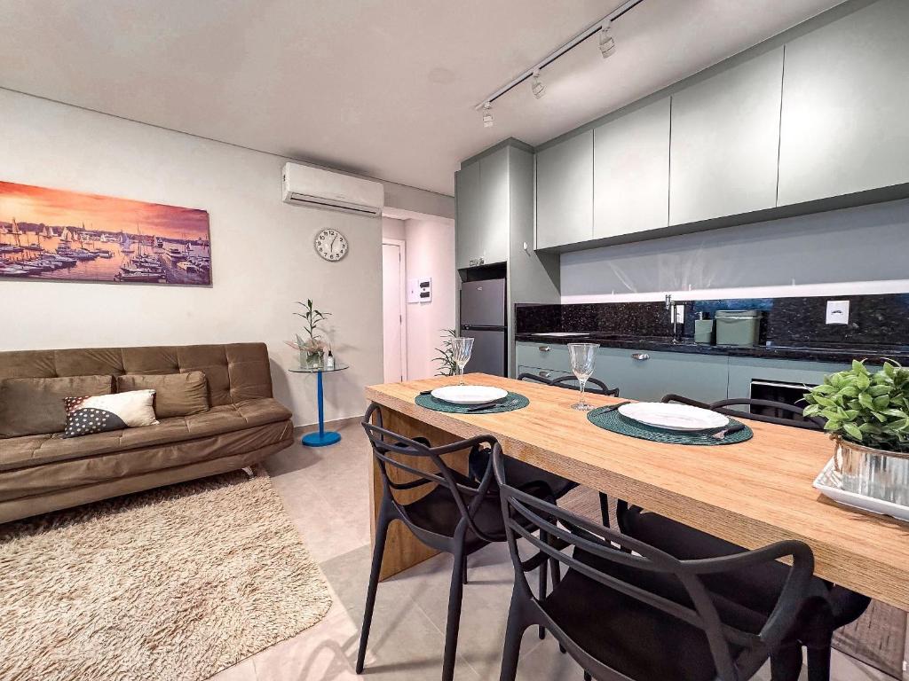 a kitchen and living room with a table and a couch at Flat Completo c/ Piscina e Garagem in Brusque