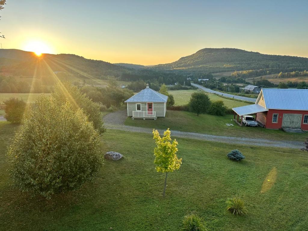 a house in a field with the sunset in the background at La laiterie in Ham Nord
