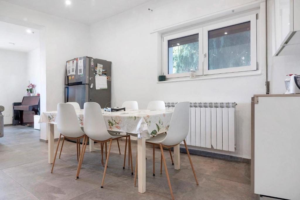 a dining room with a table and white chairs at Il Gelsomino in Porto Ceresio