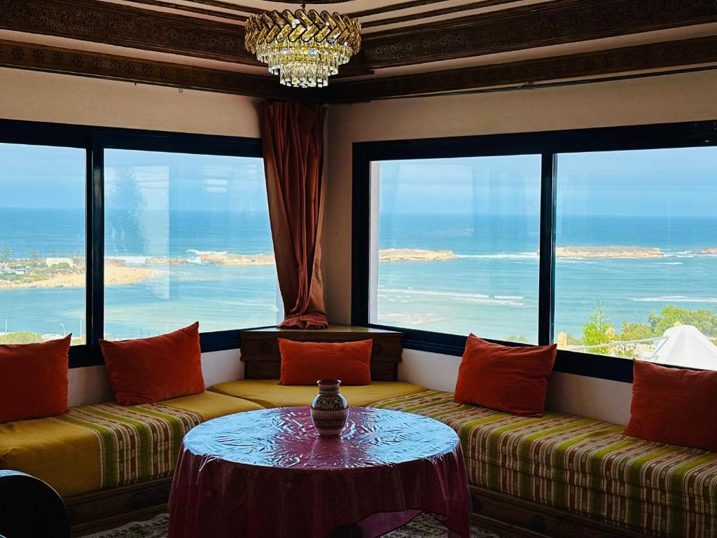 a living room with a couch and a table at Le grand château Vue sur Mer uniquement les familles in Oualidia