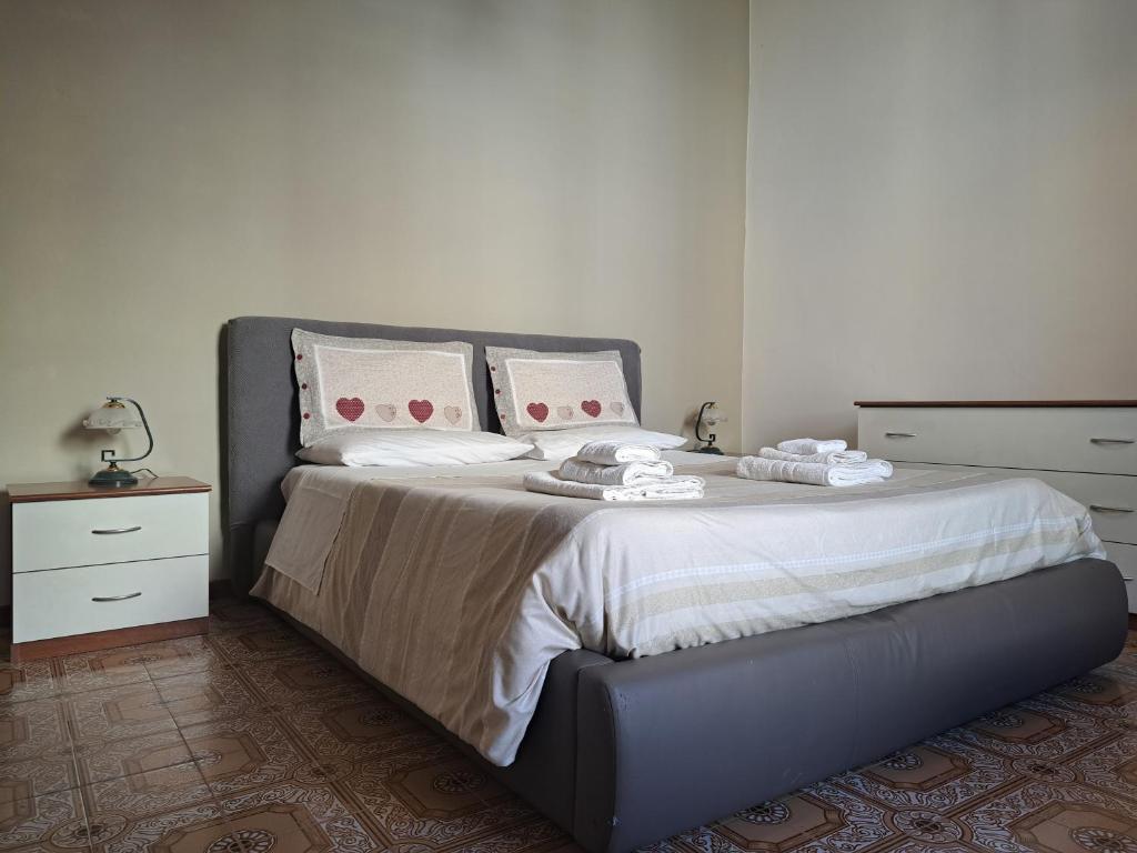 a bedroom with a large bed with white sheets and pillows at Due finestre sul cortile in Novi Ligure