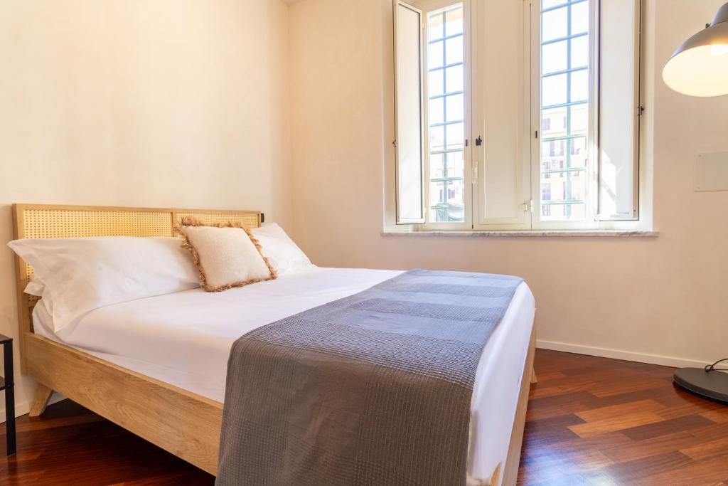 a bed in a room with a large window at Apartment Next to St Peter in Rome