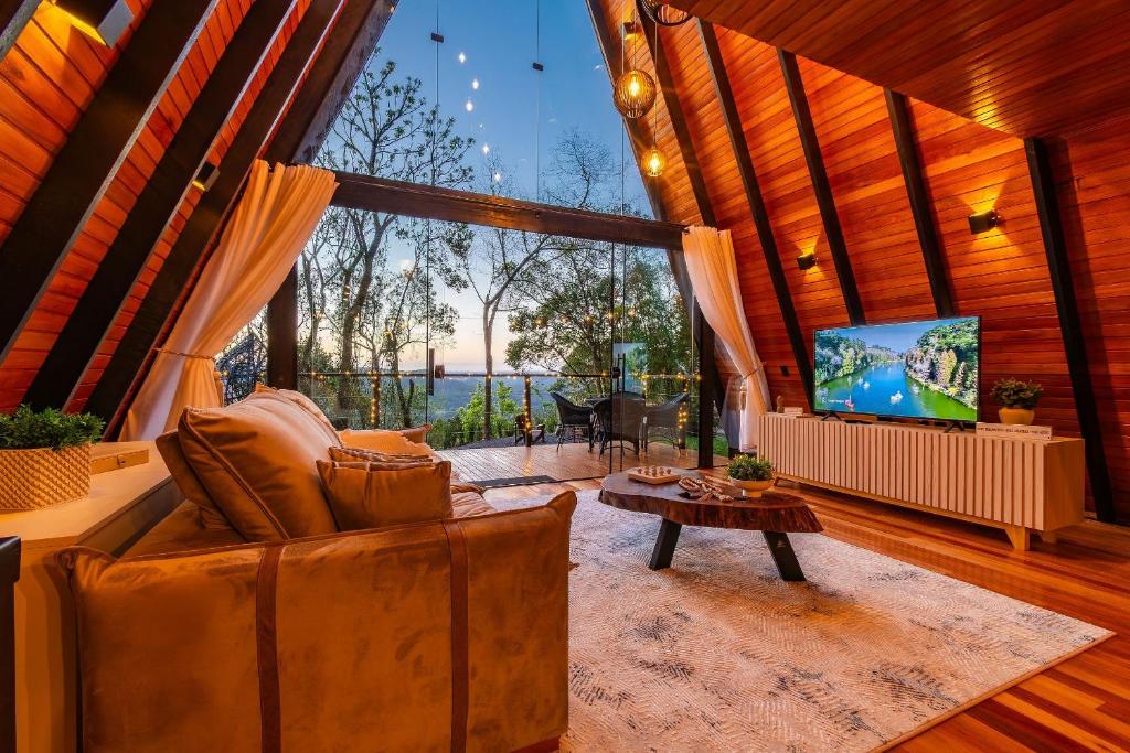 ein Wohnzimmer mit Sofa und Fernseher in der Unterkunft Cabana Lios in Gramado