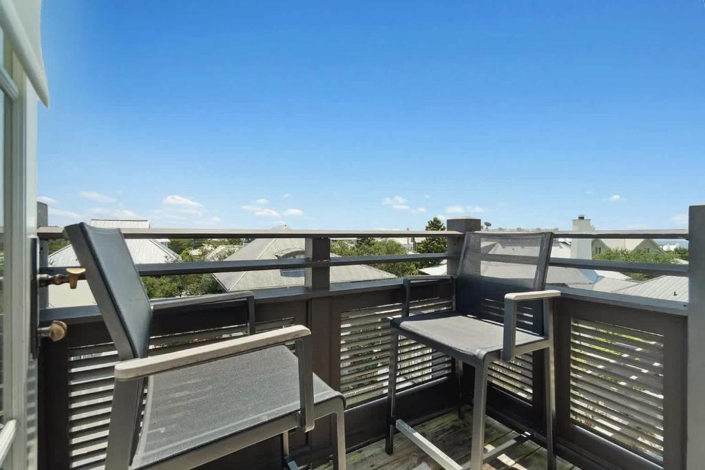 a balcony with two chairs and a table at Elegant Three Bedroom Condo Near Rosemary Beach in Rosemary Beach