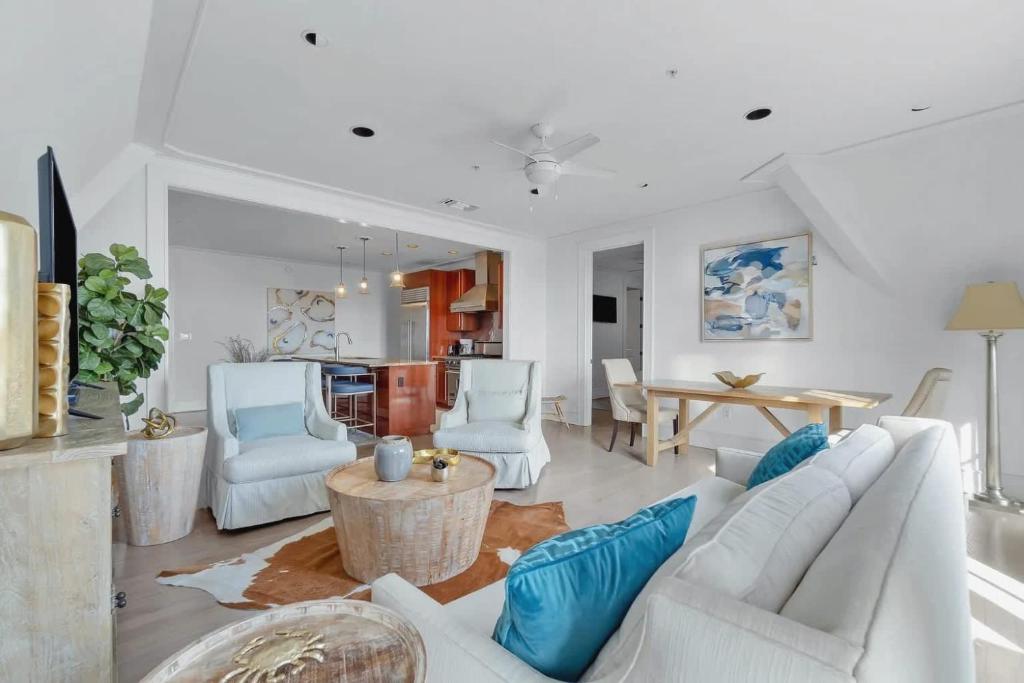 a living room with white furniture and a table at Elegant Three Bedroom Condo Near Rosemary Beach in Rosemary Beach