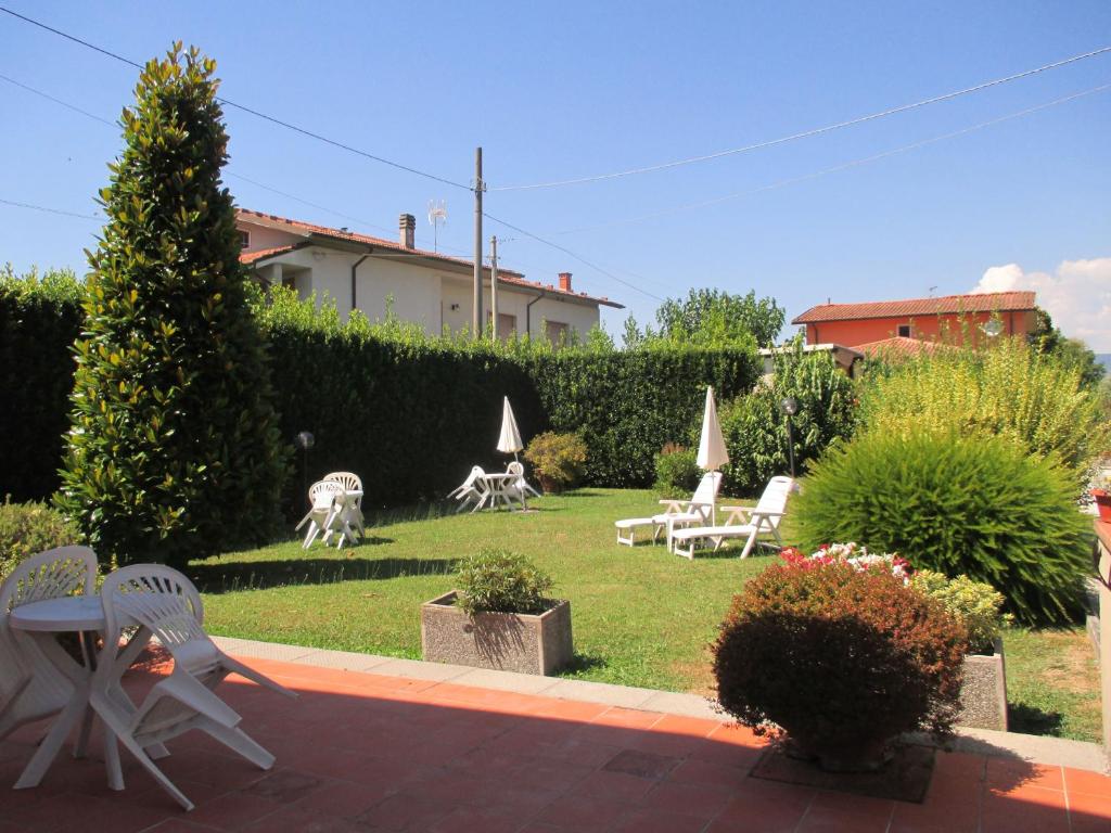 un jardín con sillas y sombrillas en el césped en Affittacamere Villa Delia, en Lucca