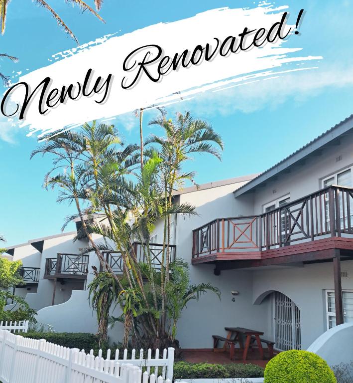 a white building with a balcony and a sign that reads newly reopened at 4 La Toinette in Ballito