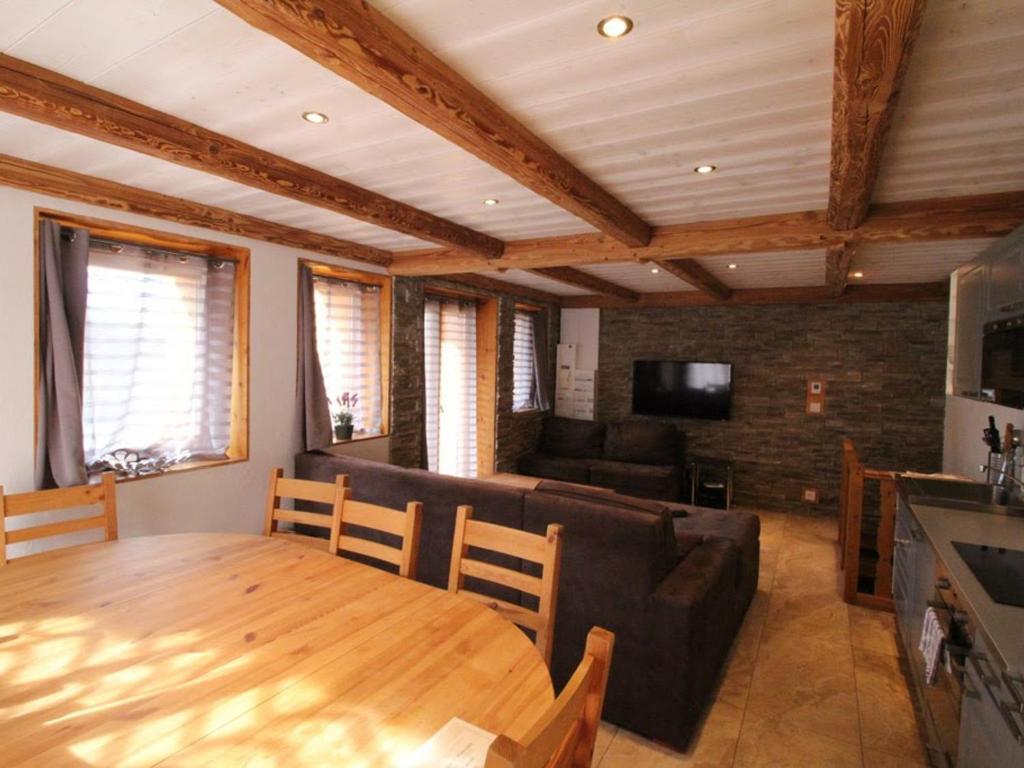 a living room with a table and a couch at Spacieux appartement 5 pièces près des pistes, jusqu'à 12 personnes, parking et balcons - FR-1-411-851 in Landry