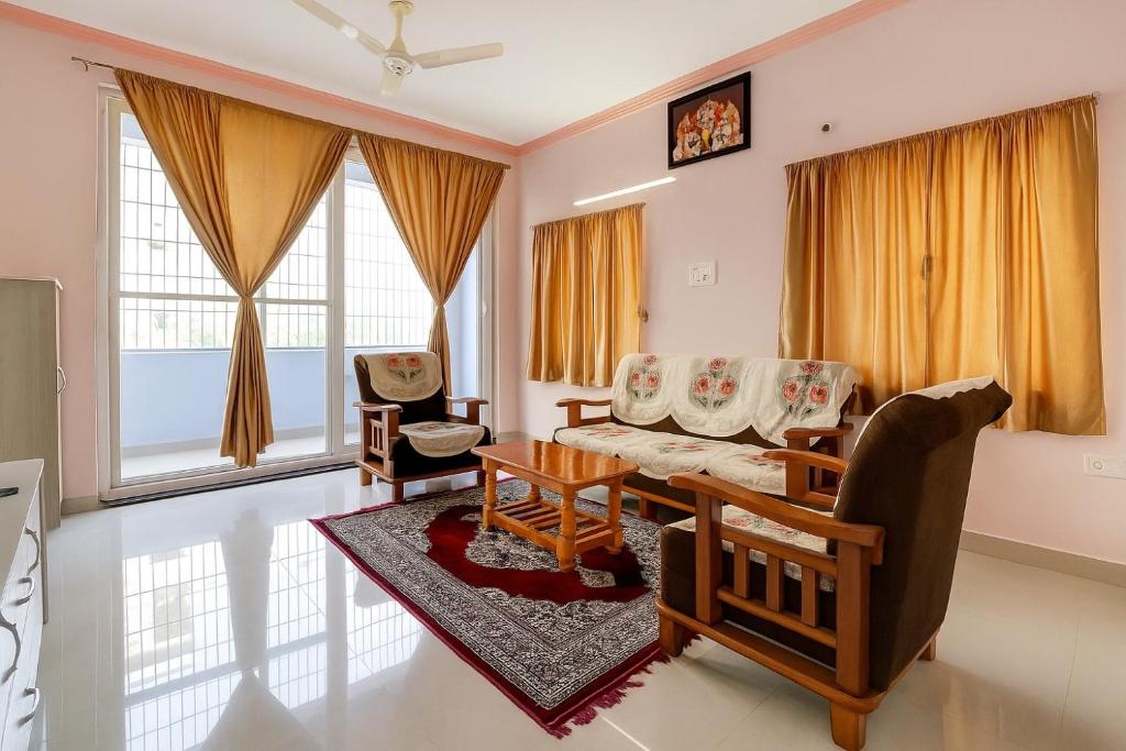 a living room with a couch and a table at Yashwithaa Homestay Tirupati - New Hill View Apartments with Balcony, AC, WiFi, TV in Tirupati
