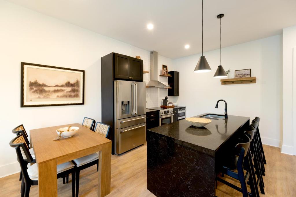 a kitchen and dining room with a table and a refrigerator at OS Hotel in Ocean Springs