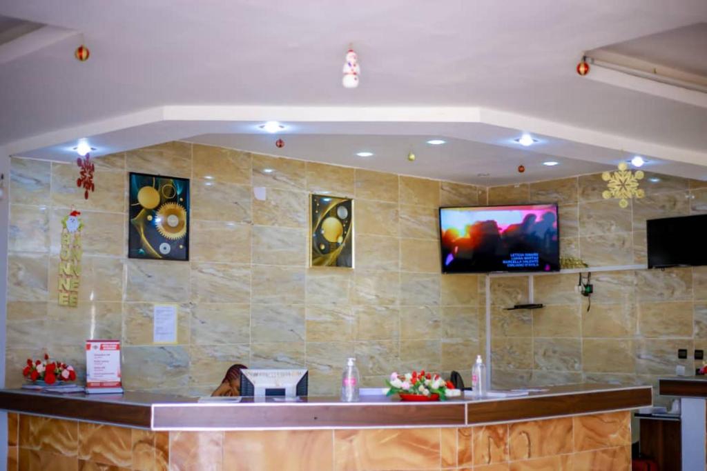 a bar with a flat screen tv on a wall at Hotel Etoile De Kennedy in Bouaké