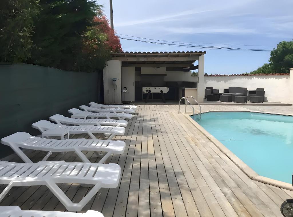 a row of lounge chairs next to a swimming pool at Chambre D’hôtes La Bonne Mine in Le Fraysse