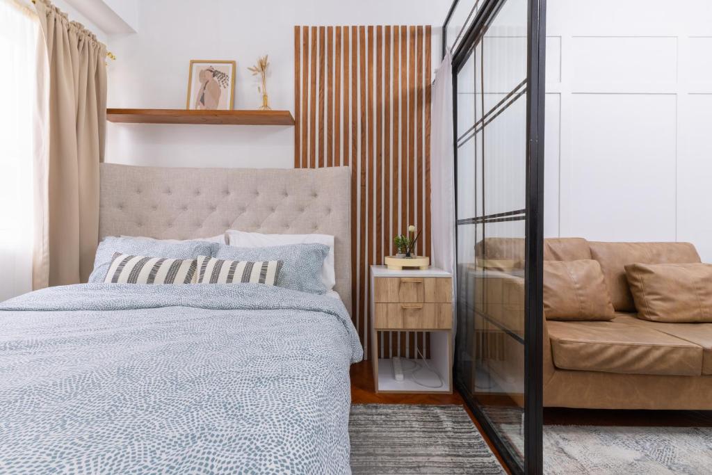 a bedroom with a bed and a couch at 1BR Condo with Free Parking at SMDC Trees Residences, Fairview Quezon City in Manila