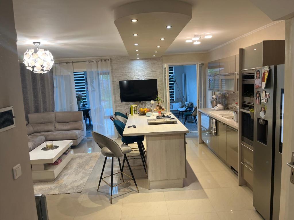 eine Küche und ein Wohnzimmer mit einer Couch und einem Tisch in der Unterkunft Maison Chic à 10min du circuit des 24H in Allonnes