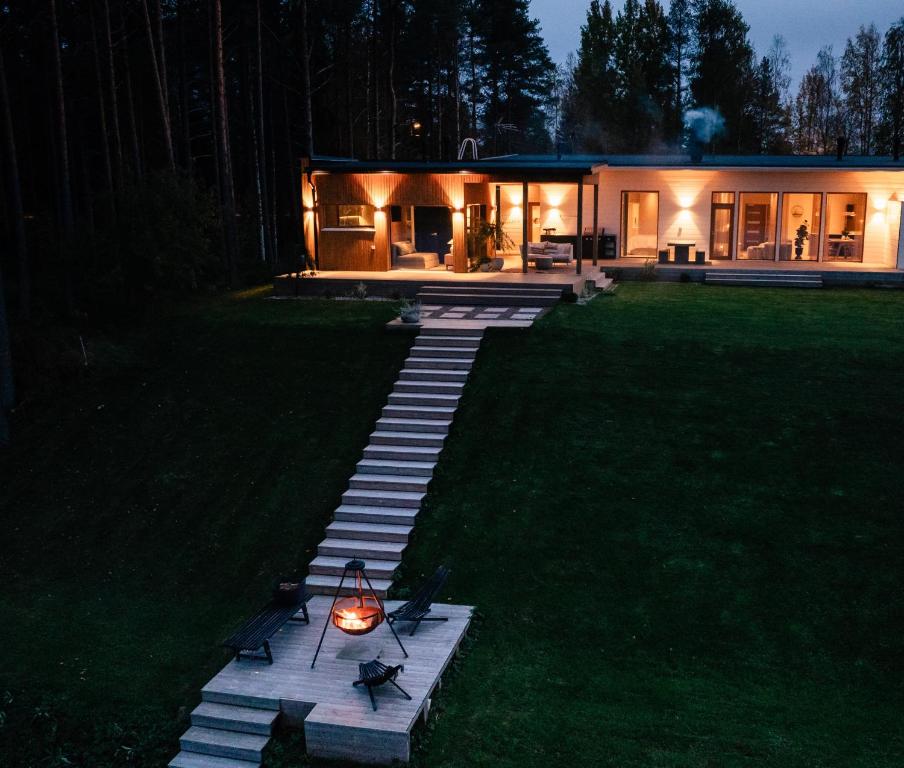 una casa con un camino en el patio por la noche en Lapland Riverside Escape, en Rovaniemi