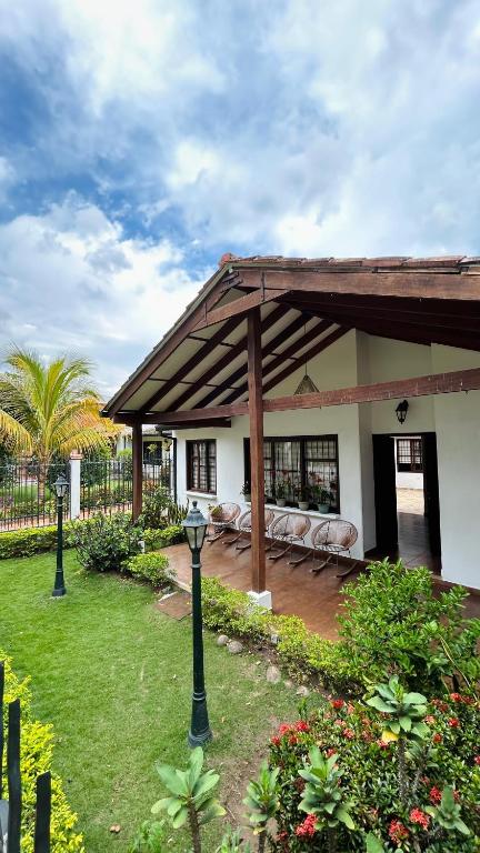 una casa con un pabellón con sillas y un patio en Isabelu, en Guaduas