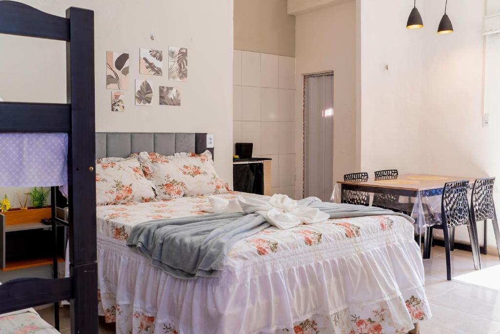 a bedroom with a bed with a table and a dining room at Vila Davi Jeri - Flats e Casa in Jericoacoara