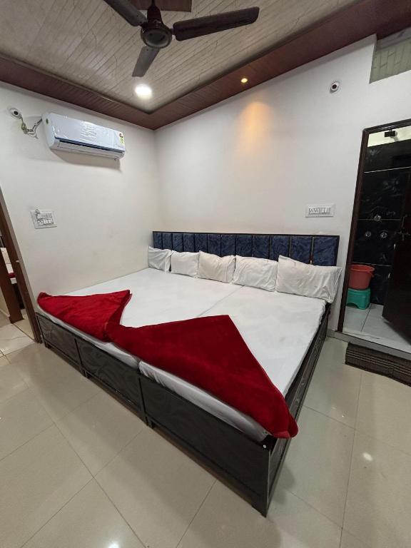 a bed in a room with a red blanket on it at Annapurna Hotel in Ujjain