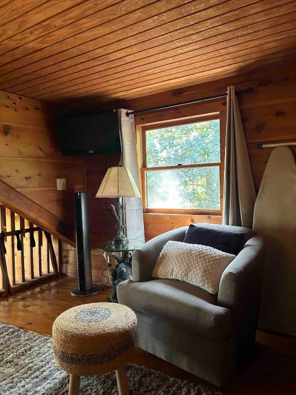 een woonkamer met een bank en een raam bij Mountain Tranquility Romantic-Hot Tub-Cabin -View in Helen