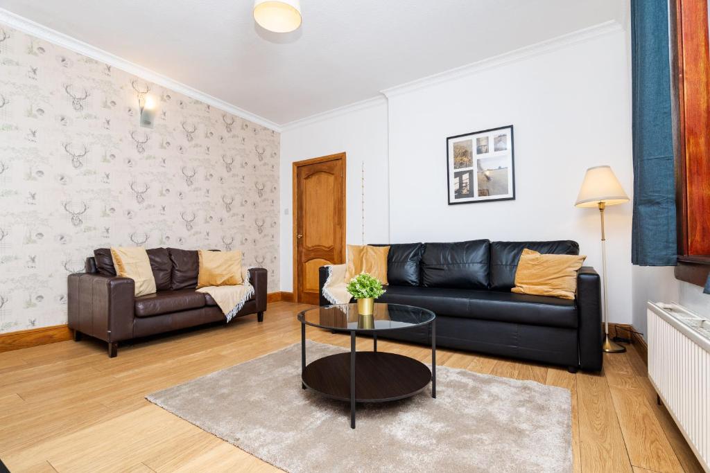 ein Wohnzimmer mit Couch und Tisch in der Unterkunft 2Bed Upper Cottage Flat-On Street Parking in Falkirk