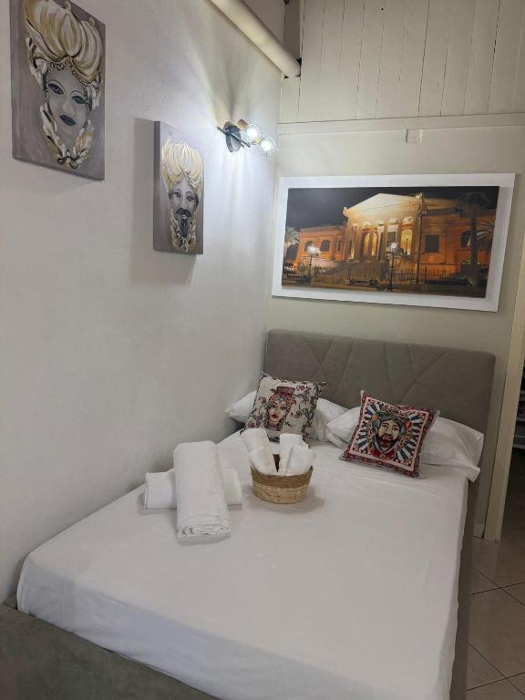 a bedroom with a white bed with a basket on it at Casa Bastiano in Palermo