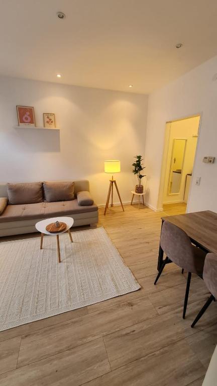 a living room with a couch and a table at Deichliebe 3 - gemütlich, zentral und modern- Inklusive privater Stellplatz im Parkhaus 2min zu Fuß entfernt in Bremerhaven