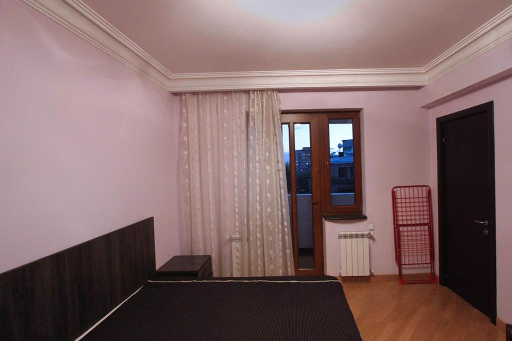 a living room with a bed and a window at Caliseum Sayat-Nova 33 in Yerevan