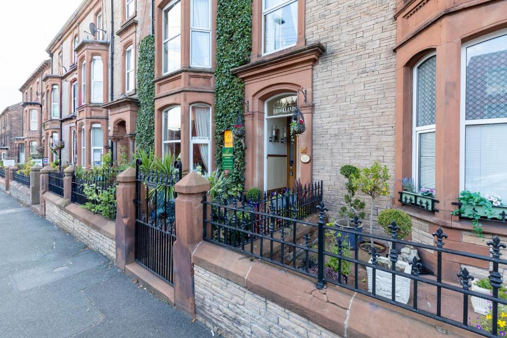 a fence in front of a building with plants at Brooklands 5 Star Guest House in Penrith