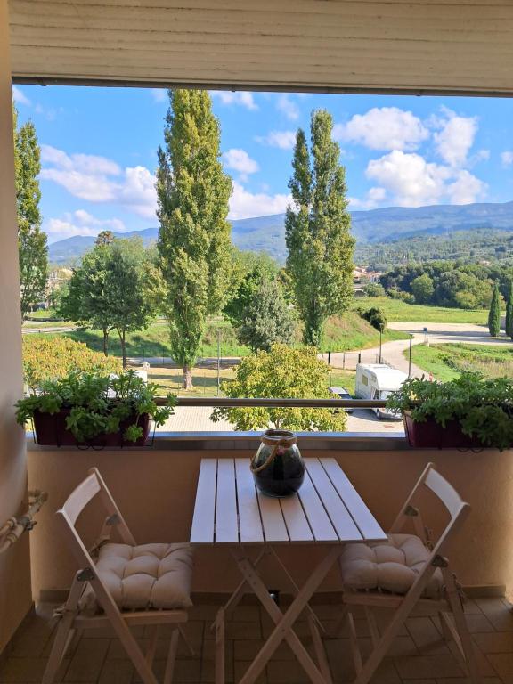 a table and chairs in front of a window with a view at Interno 10 in Capolona