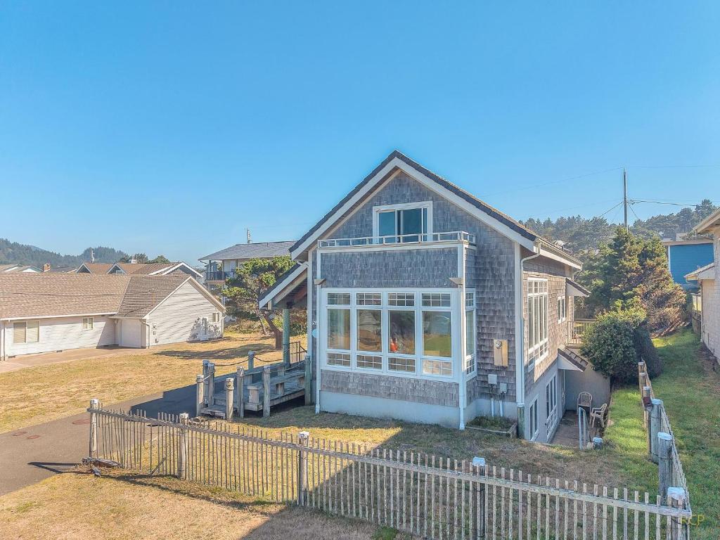 a small house with a fence in a yard at The Tides Inn in Lincoln City