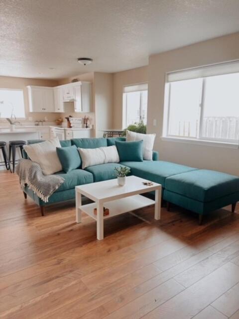 a living room with a green couch and a table at Centrically Located Hillsboro Home in Hillsboro