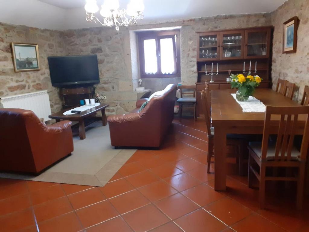 a living room with a table and chairs and a television at Casa do Galego 