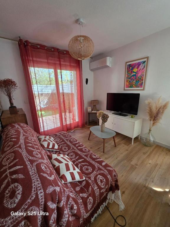 a bedroom with a bed and a large window at Appartement RDC - Grau du Roi in Le Grau-du-Roi