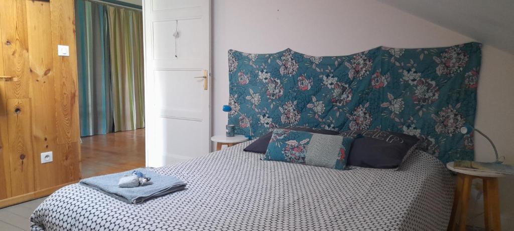 a bedroom with a bed with a head board and pillows at Chambre privée chez l'habitant in Roanne