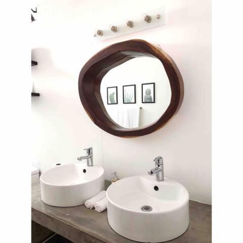 a bathroom with two sinks and a mirror on the wall at Downtown Casa Conchita Guest Suites in Sayulita