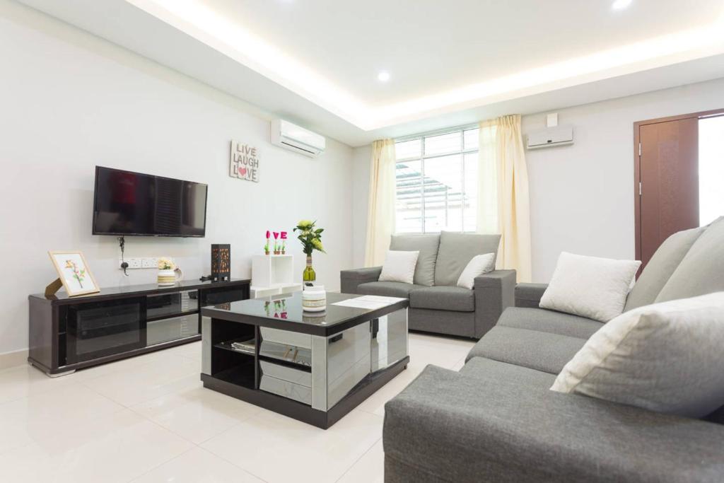 a living room with a couch and a tv at Hin Loi Homes in Kota Kinabalu