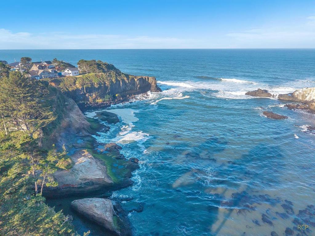 an aerial view of a rocky coastline with the ocean at Pirates Cove in Depoe Bay