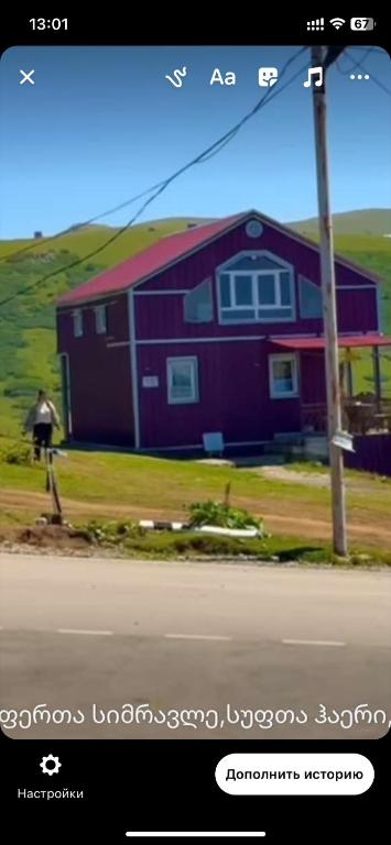 a red house with a pole in front of it at Guest house sofia in Gomi