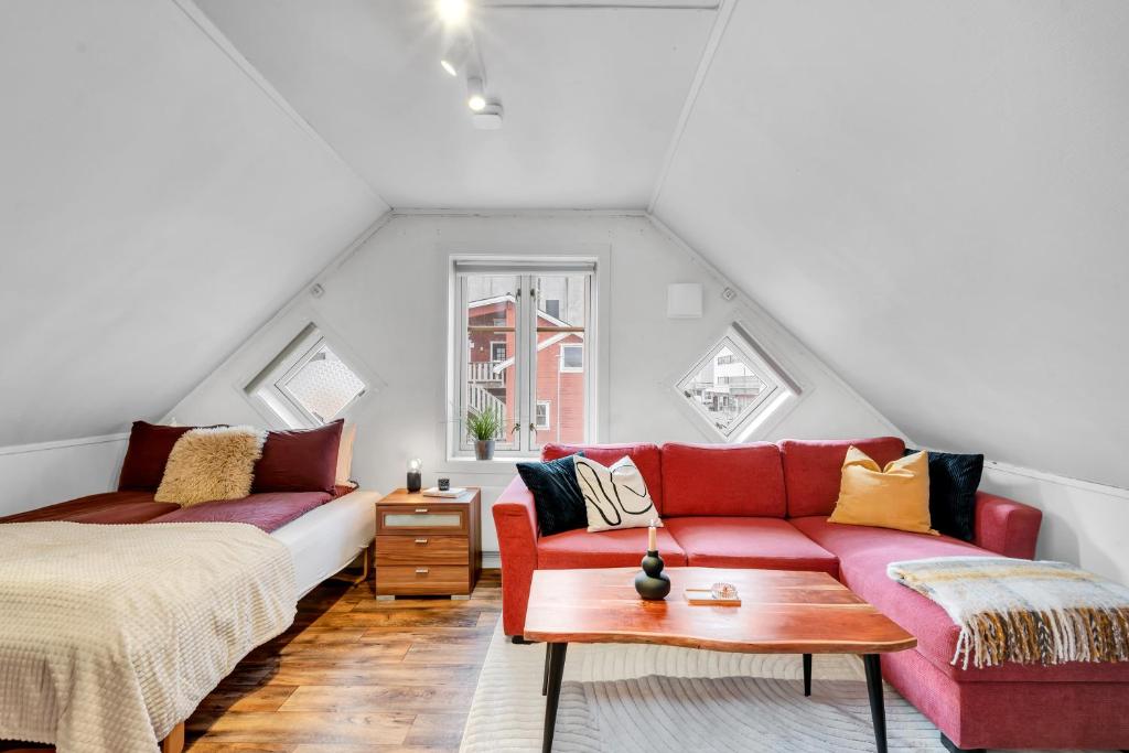 a living room with a red couch and a table at Studio By The Bridge in Tromsø