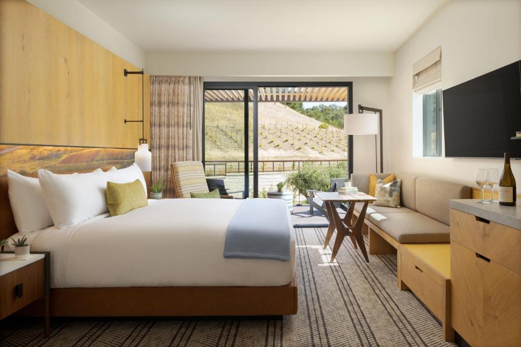 Un dormitorio con una cama grande y una sala de estar. en Appellation Healdsburg, en Healdsburg