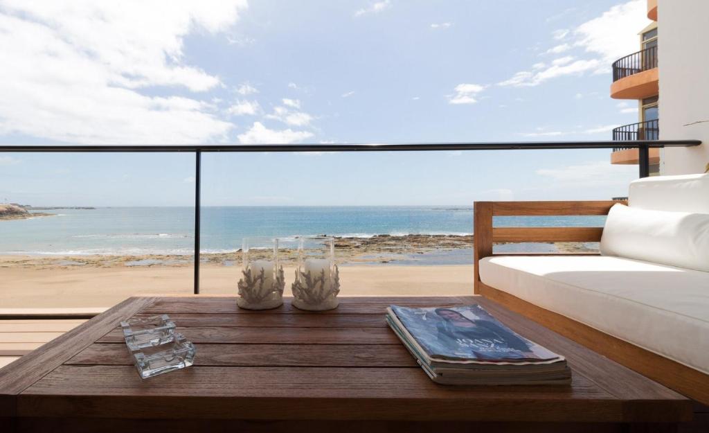 Habitación con cama, mesa y vistas a la playa. en Extra Luxurious Apartment on the Beachfront., en Salinetas