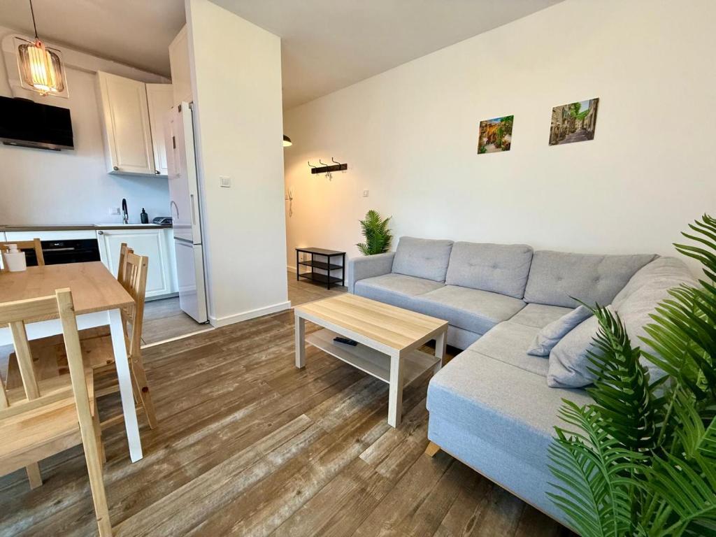 una sala de estar con un sofá y una mesa en Aluzyjna Residence by JumpInHere, en Varsovia