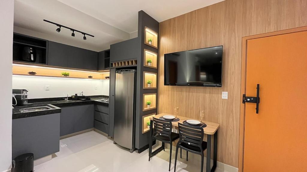 a kitchen with a table and chairs and a television at Anápolis / Suíte Cid. Universitária in Anápolis