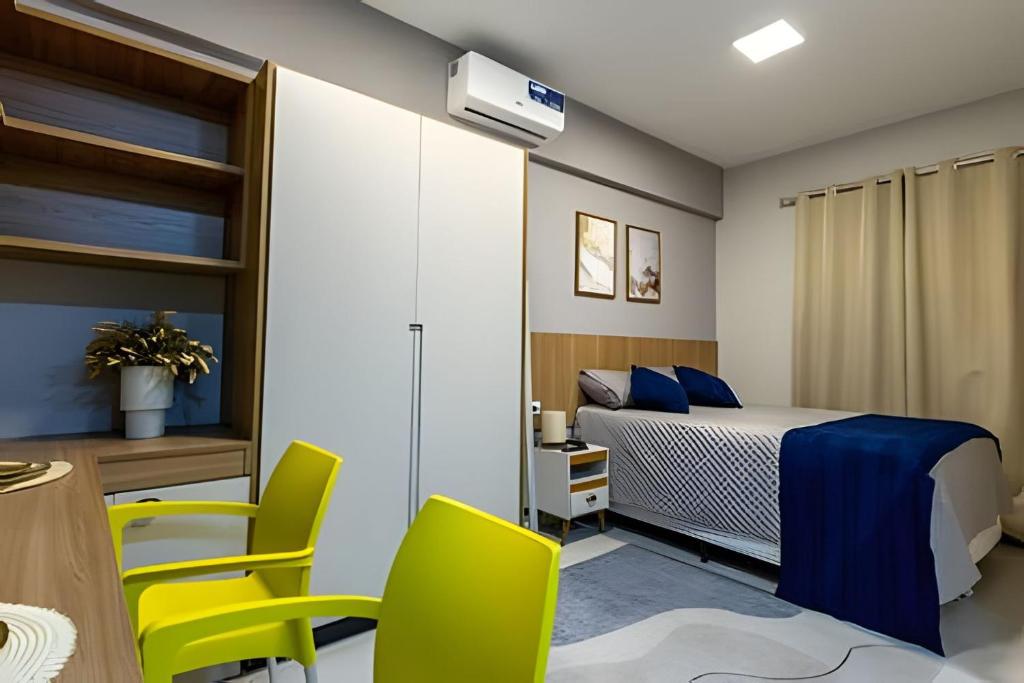 a bedroom with a bed and a table and chairs at Flats Cotia in Cotia
