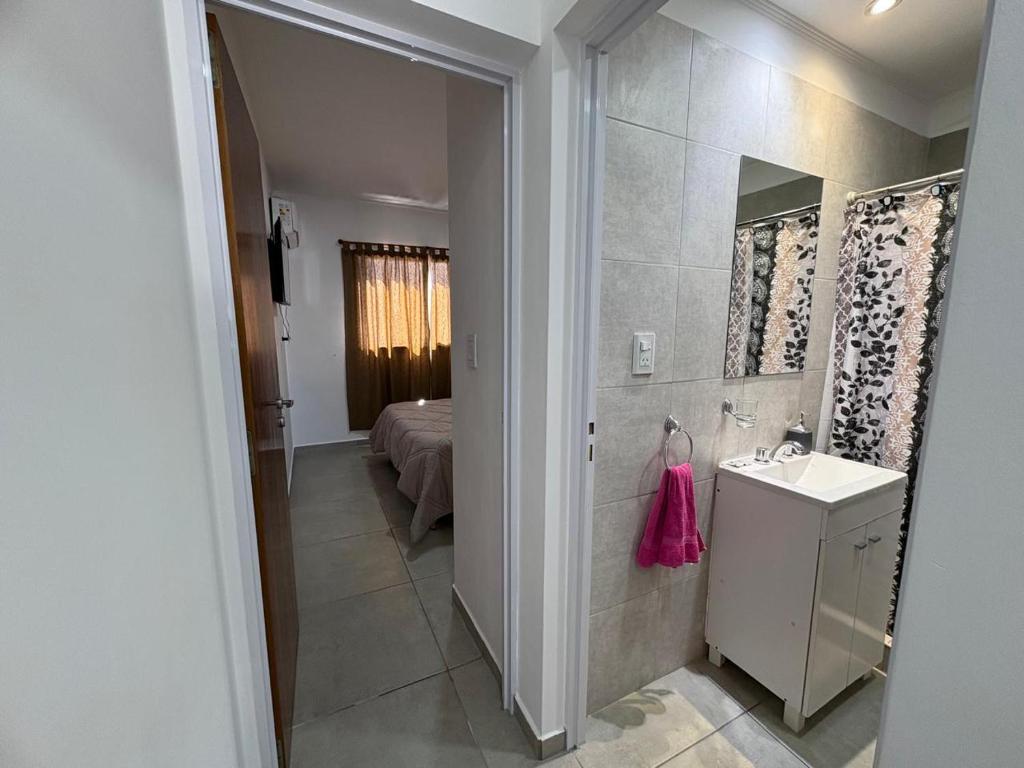 a bathroom with a sink and a bed in a room at Suite Alem a metros Peatonal San Martin in Paraná