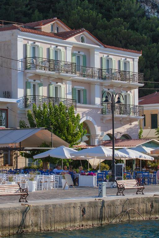 a large building with tables and umbrellas in front of it at Samaina Port Hotel in Karlovasi